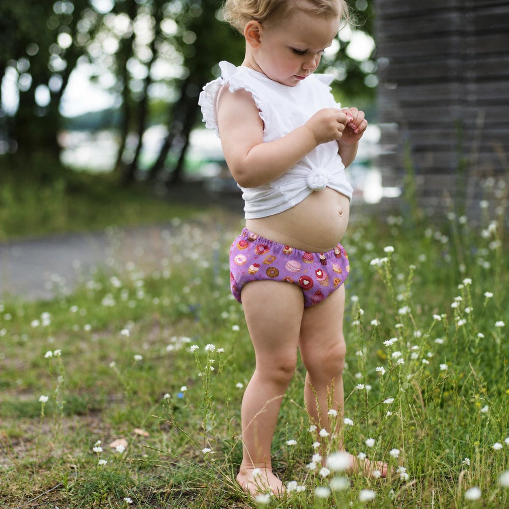 Meisje in het gras met oefenbroekjes met snoepjes